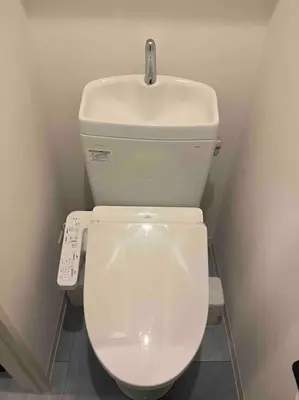 a white toilet in a bathroom with a remote control at Holy Planet in Tokyo