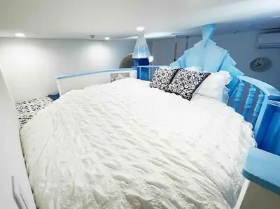 a blue bedroom with a white bed with pillows at Holy Planet in Tokyo