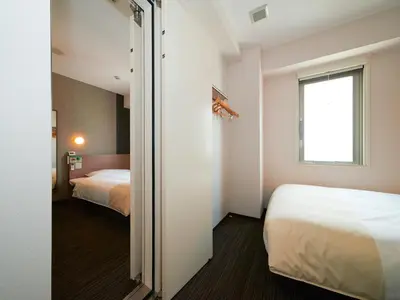 a hotel room with a bed and a window at Super Hotel Shinjuku Kabukicho in Tokyo