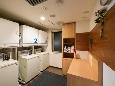 a kitchen with white appliances and wooden cabinets at Super Hotel Shinjuku Kabukicho in Tokyo