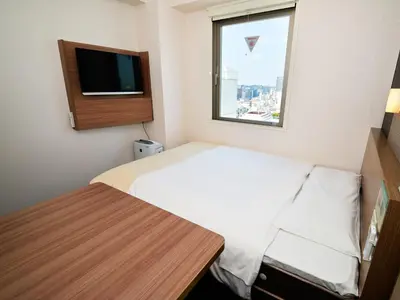 a small room with a bed and a window at Super Hotel Shinjuku Kabukicho in Tokyo