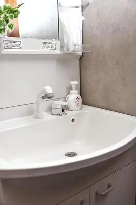 a white sink in a bathroom with a mirror at \u548c\u6c23\u4f1a\u3005\u90fd\u7acb\u5bb6\u653f Wakiaiai Toritsukasei in Tokyo