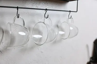 four empty wine glasses hanging on a wall at \u548c\u6c23\u4f1a\u3005\u90fd\u7acb\u5bb6\u653f Wakiaiai Toritsukasei in Tokyo