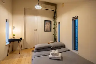 a bedroom with a bed with two white shoes on it at HAN'S EBISU - Shibuya - Entire House for Max 10 ppl in Tokyo