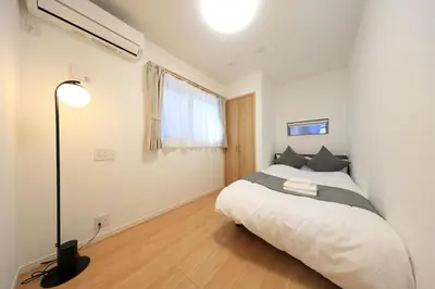 a bedroom with a bed and a lamp in it at Bliss IKEBUKURO in Tokyo