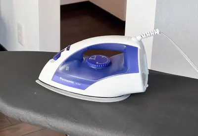 a white and blue iron sitting on a table at Family Stay Tokyo Hikifune in Tokyo