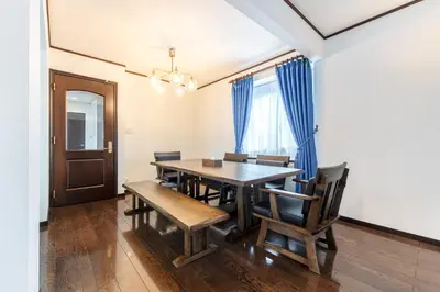 a dining room with a wooden table and chairs at Family Stay Tokyo Hikifune in Tokyo