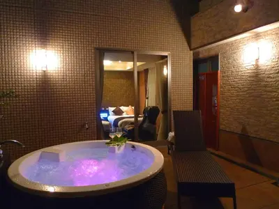 a jacuzzi tub in a room with a bedroom at Hotel Coco Grand Kitasenju in Tokyo