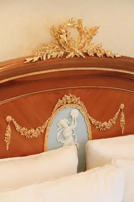 a bed with a wooden head board with a gold trim at Hotel Coco Grand Kitasenju in Tokyo
