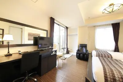 a hotel room with a bed and a desk with a computer at Hotel Coco Grand Kitasenju in Tokyo