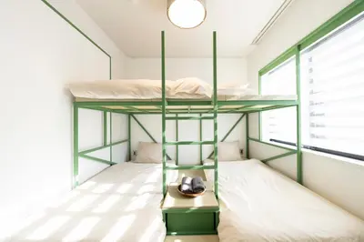 a bedroom with two bunk beds and a window at Courtyard HIROO in Tokyo