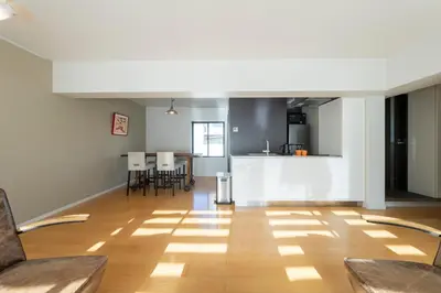 a living room with wooden floors and a kitchen at Courtyard HIROO in Tokyo