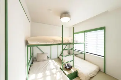 two bunk beds in a room with a window at Courtyard HIROO in Tokyo