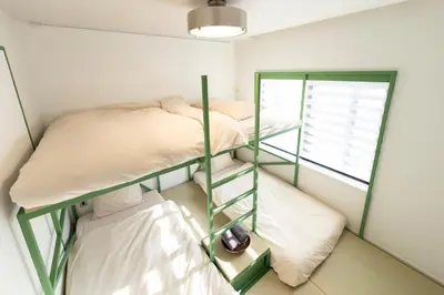 two bunk beds in a room with a window at Courtyard HIROO in Tokyo