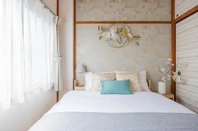 a bedroom with a white bed with a blue pillow at Healing Palace Hirai tokyo down town in Tokyo