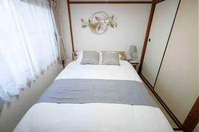 a bedroom with a large bed with a chandelier at Healing Palace Hirai tokyo down town in Tokyo