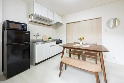 a kitchen with a wooden table and a black refrigerator at Healing Palace Hirai tokyo down town in Tokyo