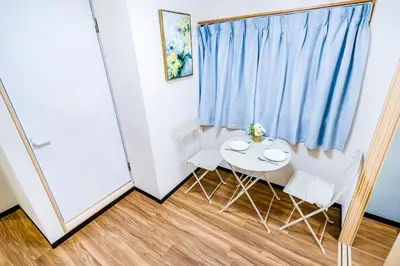 a small table and chairs in a room with a blue curtain at Shinjuku Ryokan Retreat丶Local Tokyo Experience & Short Trips Hub丶walk to Shinjuku station Y05C in Tokyo