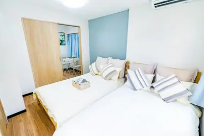 two white beds in a room with a mirror at Shinjuku Ryokan Retreat丶Local Tokyo Experience & Short Trips Hub丶walk to Shinjuku station Y05C in Tokyo