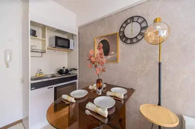 a kitchen with a table and a clock on the wall at G57\u65b0\u5bbf\u6700\u4e2d\u5fc3 \u6771\u65b0\u5bbf\u7ad95\u5206-Shinjuku center 5 mins to Station, Max 4 \u76f4\u8fbe\u65b0\u5bbf \u6d89\u8c37 \u8868\u53c2\u9053 \u6c60\u888b \u4e0a\u91ce \u4ee3\u4ee3\u6728 \u94f6\u5ea7 \u539f\u5bbf in Tokyo