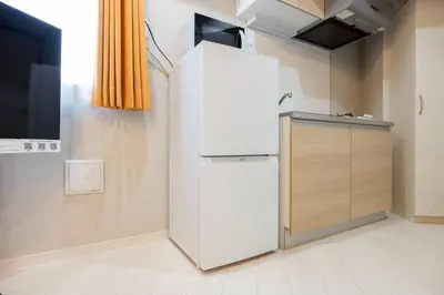 a white refrigerator in a kitchen with a counter at Mat Hikifune in Tokyo