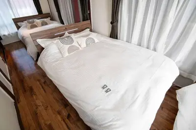 a bedroom with two beds with white sheets at Cozy Home YOTSUGI tokyo down town in Tokyo