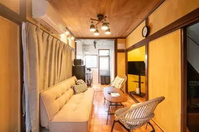 a living room with a couch and a table and chairs at Cozy Home YOTSUGI tokyo down town in Tokyo