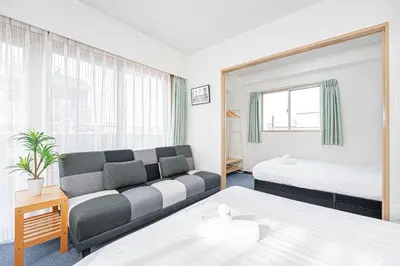 a hotel room with two beds and a couch at Fukuei Stay Tokyo in Tokyo