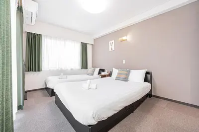 a hotel room with two beds and a window at Fukuei Stay Tokyo in Tokyo
