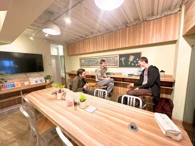 a group of people sitting at a table in a room at A16 HOSTEL TOKYO in Tokyo