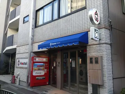 a store front of a building with a red door at A16 HOSTEL TOKYO in Tokyo
