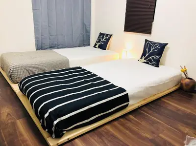 two beds sitting next to each other in a room at Tanuki Shinjuku in Tokyo
