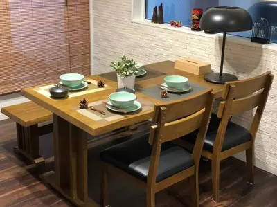 a wooden table with two chairs and a table with green dishes at Tanuki Shinjuku in Tokyo