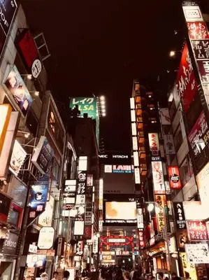 a busy city street at night with many signs at Tanuki Shinjuku in Tokyo