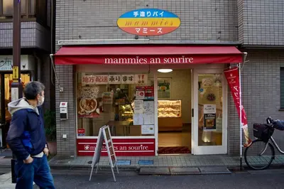 a man walking in front of a sandwich shop at [空港直接アクセス] JR山手線日暮里駅徒歩8分アパートメント/千駄木ハウス in Tokyo