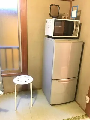 a microwave on top of a refrigerator with a stool at 10 minutes direct to Shibuya Crossing! Heart of Tokyo! Kamiuma in Tokyo