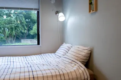 a bedroom with a bed with pillows and a window at \u8d64\u5742\u516d\u672c\u6728\u30a8\u30ea\u30a2\u3000\u30de\u30f3\u30b9\u30ea\u30fc\u30de\u30f3\u30b7\u30e7\u30f3 in Tokyo