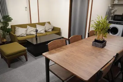 a living room with a couch and a table and chairs at \u99c5\u5f92\u6b694\u5206 \u90fd\u5fc3\u306e\u5e83\u3005\u7a7a\u9593 \u5404\u968e\u8cb8\u5207 \u9280\u5ea7 \u304a\u53f0\u5834 \u8c4a\u6d32\u3059\u3050 \u7530\u753a \u4e09\u7530\u99c5\u3082\u5229\u7528\u53ef in Tokyo