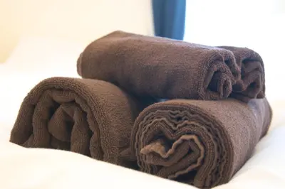 a pile of brown towels sitting on top of a bed at Yutaka bldg.302 in Tokyo
