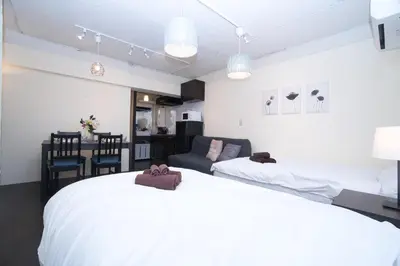 a bedroom with two beds and a living room at Yutaka bldg.302 in Tokyo