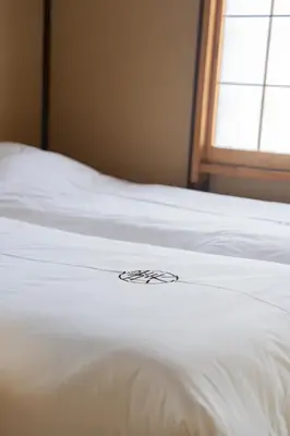 a white bed with a flower on top of it at 璞（Haku）日式旅馆/新宿繁华区域/東新宿駅徒歩4分/免費WIFI/最大可入住7人 in Tokyo