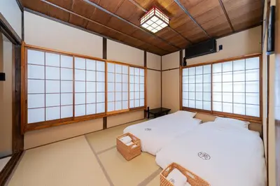 a room with two beds in it with windows at 璞（Haku）日式旅馆/新宿繁华区域/東新宿駅徒歩4分/免費WIFI/最大可入住7人 in Tokyo