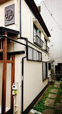 a white building with a door and a balcony at 璞（Haku）日式旅馆/新宿繁华区域/東新宿駅徒歩4分/免費WIFI/最大可入住7人 in Tokyo
