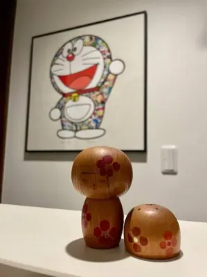 two wooden figurines sitting on a table with a picture at Tanuki Shinjuku 2 in Tokyo