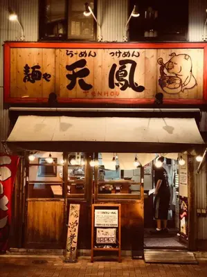 a woman standing in the doorway of a restaurant at Tanuki Shinjuku 2 in Tokyo