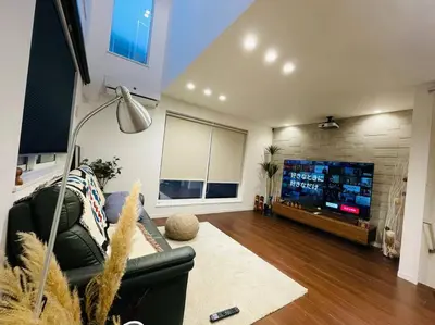 a living room with a couch and a flat screen tv at Tanuki Shinjuku 2 in Tokyo