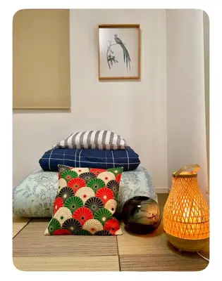 a room with a bed with pillows and a vase at Tanuki Shinjuku 2 in Tokyo