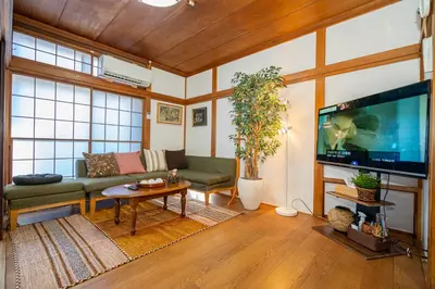 a living room with a large flat screen tv at Jujo house Direct to Shinjuku in Tokyo