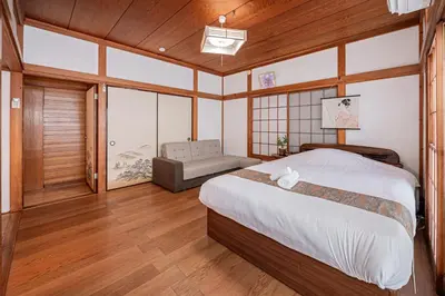 a bedroom with a bed and a couch in it at Jujo house Direct to Shinjuku in Tokyo