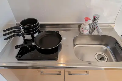 a kitchen sink with a frying pan on a stove at Aurora 5 in Tokyo